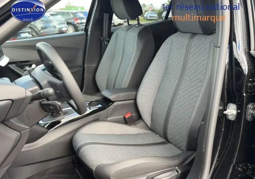 Vue intérieure côté conducteur du Peugeot 2008 noir 2025, mettant en valeur les sièges tissu gris et la console centrale brillante.