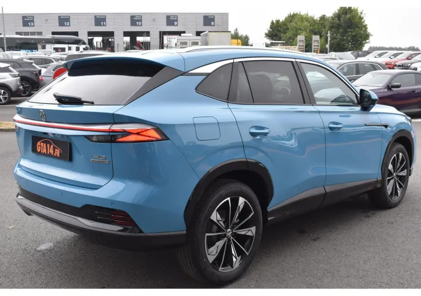 Vue 3/4 arrière droite du MG Motor EHS 1.5 Hybrid+ bleu métallisé avec jantes alliage 19 pouces et vitres surteintées.