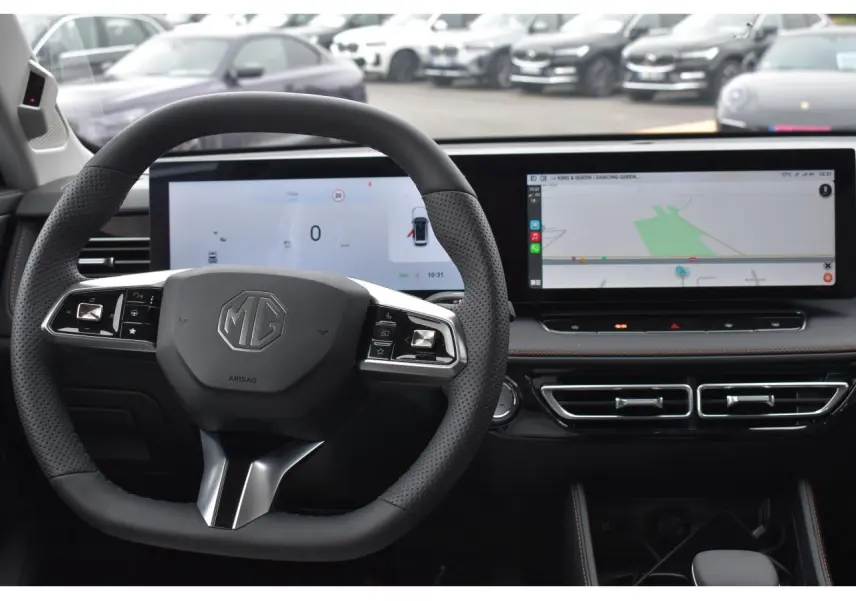 Vue intérieure centrée sur le volant et les écrans numériques du tableau de bord du MG MOTOR EHS hybride.