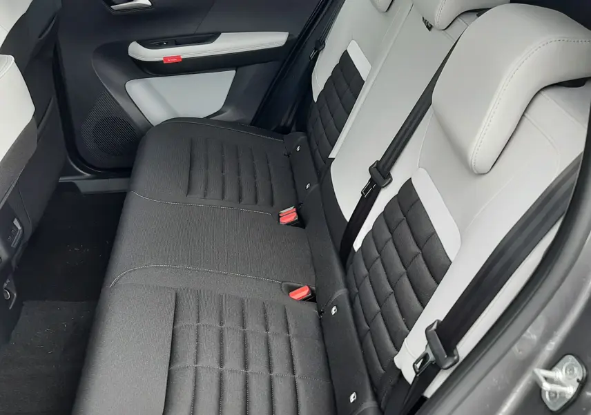 Vue intérieure côté arrière droit du Citroën C3 Aircross 2026, sièges bicolores noir et blanc avec tissu matelassé.