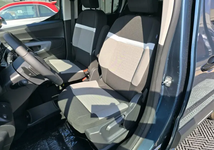 Intérieur du Citroën Berlingo bleu Kiama, vue côté conducteur sur les sièges avant en tissu bicolore.