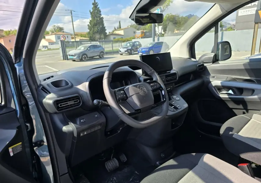 Intérieur avant du Citroën Berlingo bleu Kiama, volant cuir multifonction et tableau de bord moderne avec écran tactile.