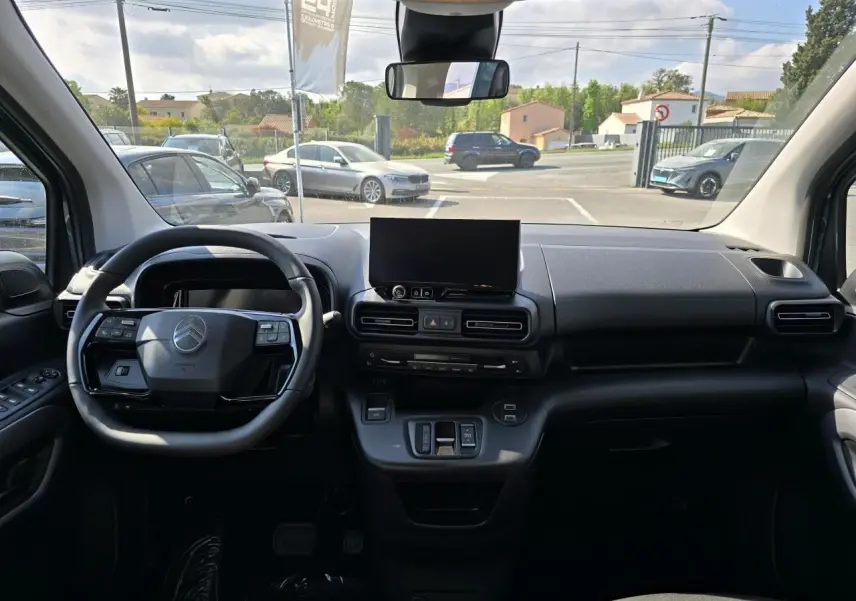 Vue intérieure du tableau de bord du Citroën Berlingo bleu Kiama, avec volant multifonction et écran tactile central.