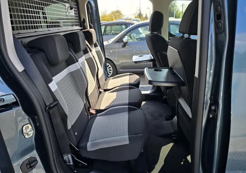 Intérieur arrière du Citroën Berlingo bleu Kiama, vue côté gauche sur les trois sièges individuels avec tablette rabattable.