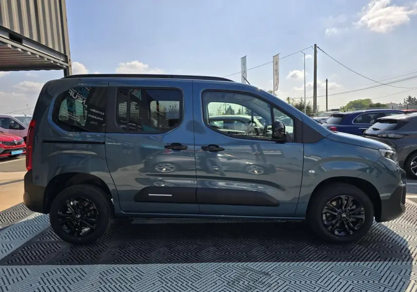 Profil latéral droit du Citroën Berlingo bleu Kiama métallisé avec vitres arrière teintées et jantes noires.