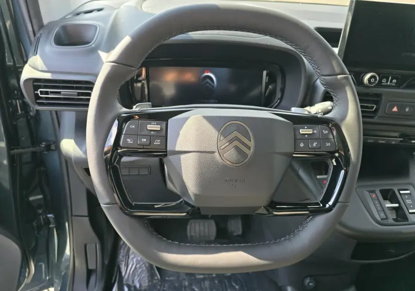 Vue rapprochée du volant cuir multifonction du Citroën Berlingo bleu Kiama 2025 avec tableau de bord moderne.