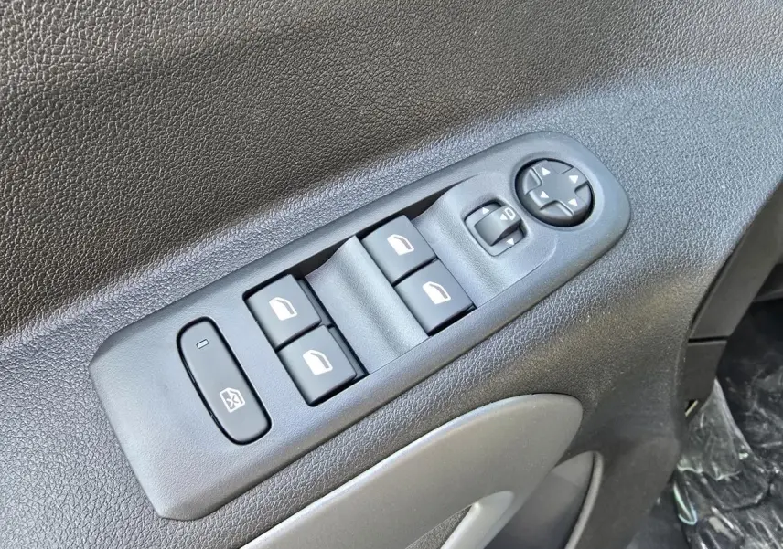 Gros plan sur les commandes des lève-vitres et rétroviseurs électriques côté conducteur du Citroën Berlingo bleu Kiama métal.