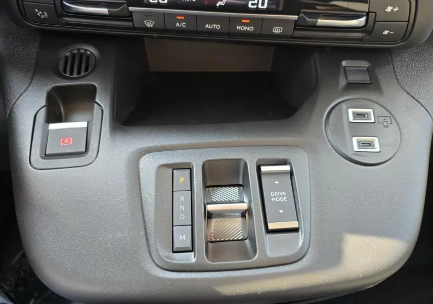 Vue rapprochée de la console centrale du Citroën Berlingo 2025, avec commandes de boîte auto et climatisation digitale.