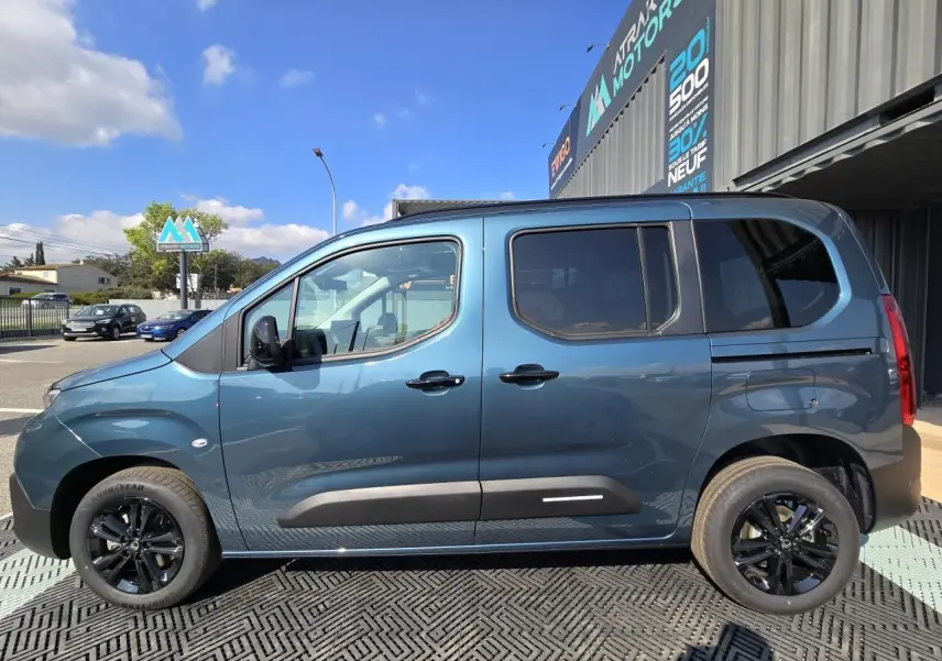Profil droit du Citroën Berlingo bleu Kiama métallisé avec vitres arrière teintées et jantes aluminium noires.
