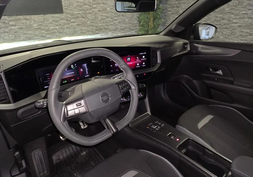 Vue intérieure côté conducteur de l'Opel Mokka-e 2025 noire, avec tableau de bord digital et volant multifonction.
