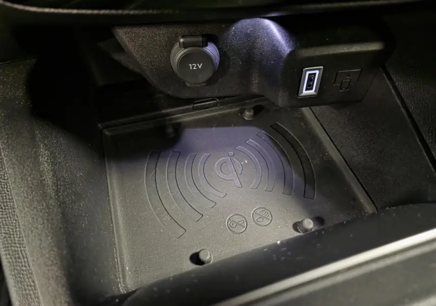 Gros plan sur le chargeur smartphone par induction et prise USB dans la console centrale d’un Opel Mokka-e noir.