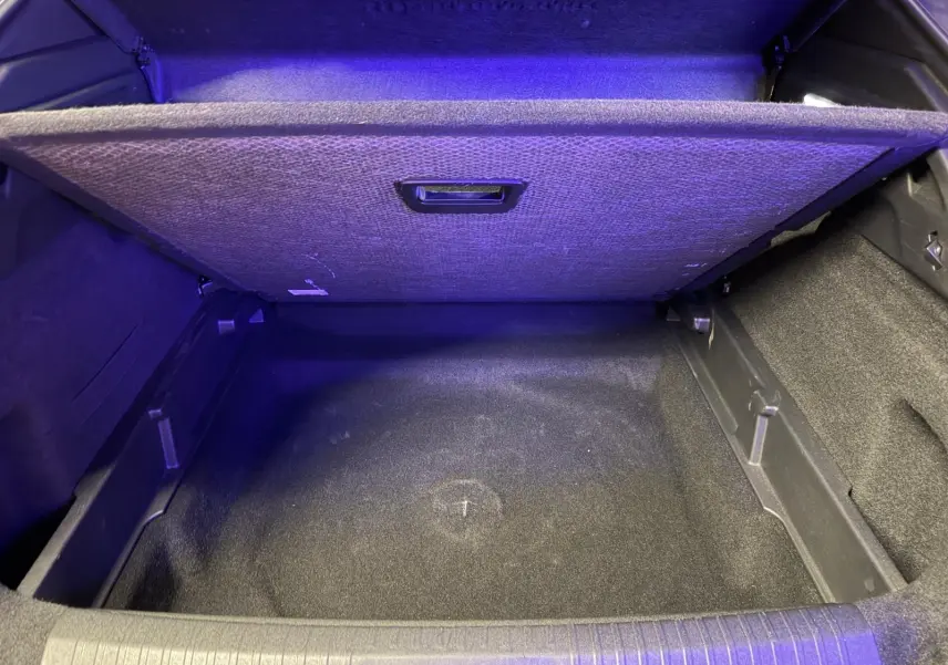 Coffre ouvert du Peugeot 3008 1.2 Hybrid 136 Allure gris, montrant le compartiment de rangement sous plancher.