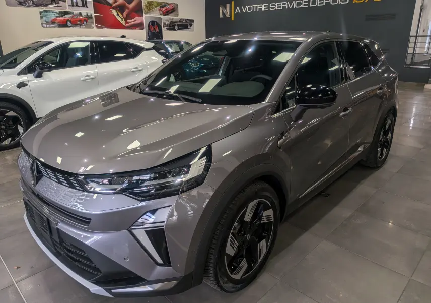 Renault Symbioz E-Tech Full Hybrid gris Cassiopé, vue 3/4 avant droit, jantes noires et détails lumineux LED.