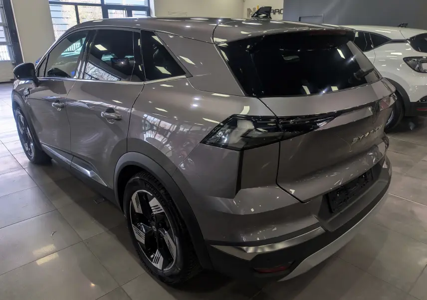 Vue 3/4 arrière droite du Renault SYMBIOZ gris Cassiopé avec feux arrière LED et jantes bicolores en concession.