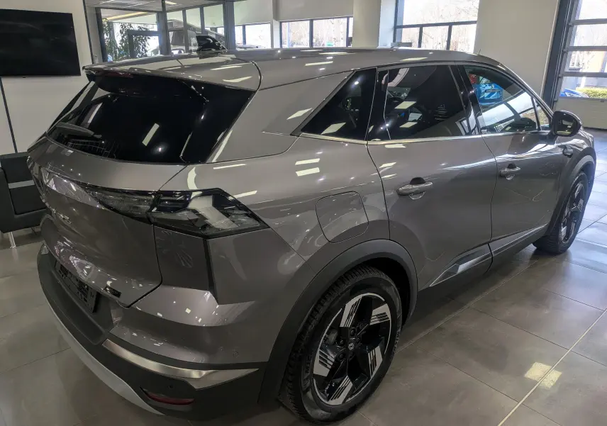 Vue 3/4 arrière droite du Renault SYMBIOZ E-TECH gris Cassiopé, avec jantes bi-ton et vitres teintées en showroom.