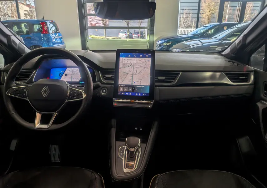 Vue intérieure du tableau de bord de la Renault Symbioz gris Cassiopé, avec écran tactile vertical et volant multifonction.