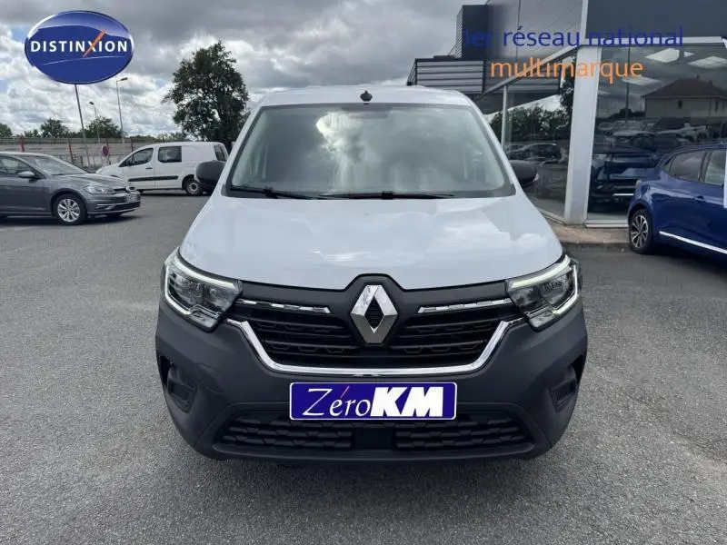 Vue de face d'un Renault Kangoo Van blanc avec calandre noire et logo Renault bien visible, sur parking extérieur.