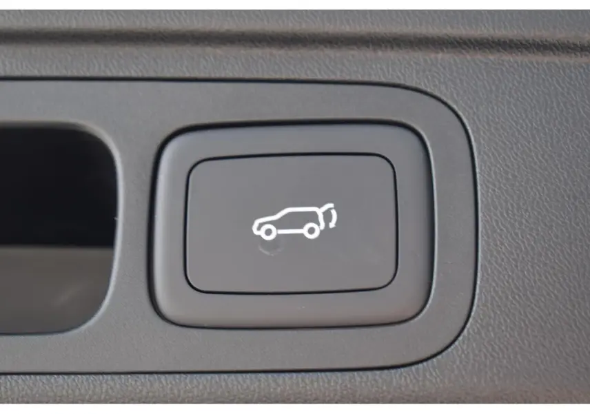 Bouton intérieur noir avec pictogramme blanc d'ouverture du hayon sur MG Motor EHS hybride 2026.