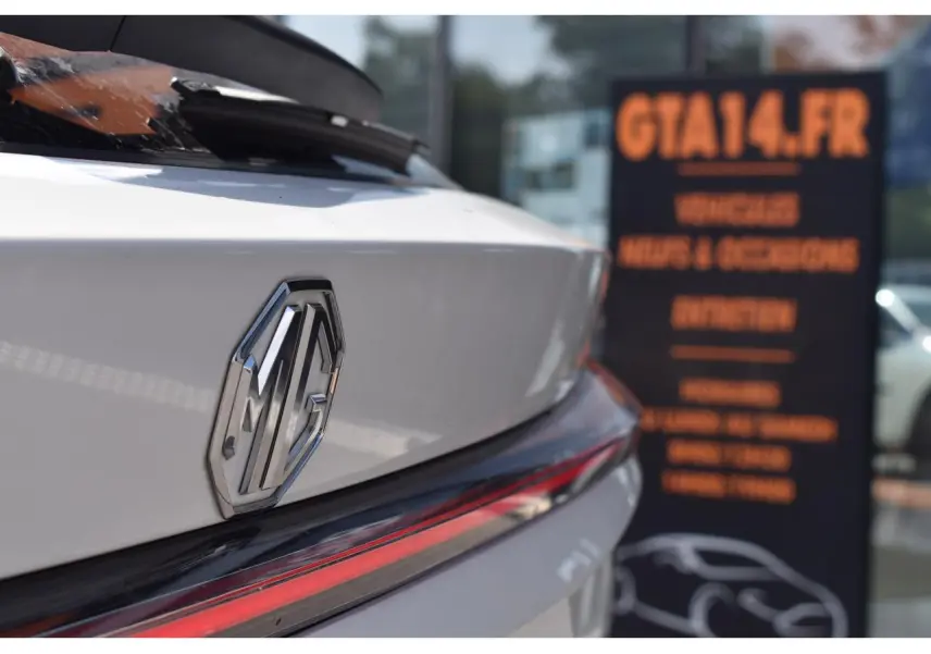 Gros plan sur l'arrière blanc du MG EHS 1.5 Hybrid+ 224 ch Luxury avec logo MG et feu arrière LED fin.