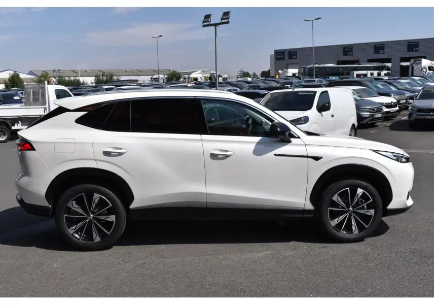 Vue profil droit du SUV MG EHS blanc métallisé, avec jantes alliage noires et vitres arrière surteintées.