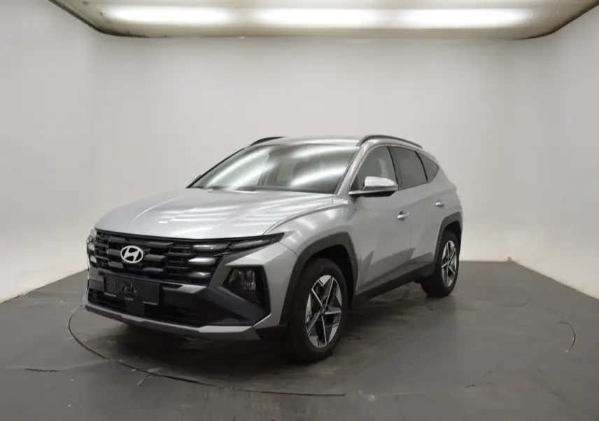 Hyundai Tucson 2025 Shimmering Silver en 3/4 avant droit, avec jantes 18 pouces et calandre noire distinctive.