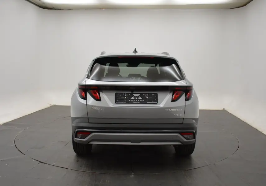 Vue arrière d'un Hyundai Tucson hybride 2025 en Shimmering Silver avec feux arrière LED distinctifs.