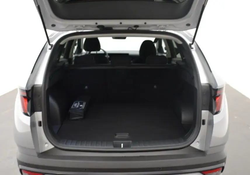 Vue arrière du Hyundai Tucson 2025 Shimmering Silver avec coffre ouvert et intérieur noir visible.