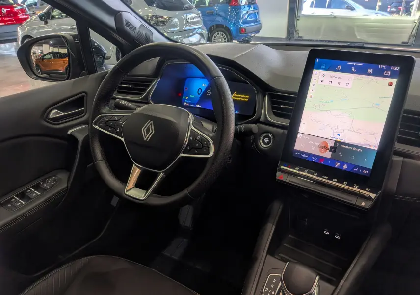 Vue intérieure côté conducteur du Renault Symbioz gris Cassiopé, avec tableau de bord numérique et grand écran tactile central.