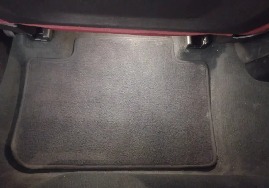 Tapis de sol noir en moquette dans l'habitacle arrière d'un BMW X3 xDrive30e blanc, vue de dessus.