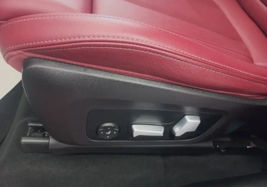 Gros plan sur les commandes électriques du siège avant rouge du BMW X3 xDrive30e 2022.