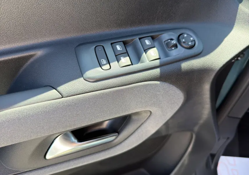 Gros plan sur la porte côté conducteur du Peugeot Rifter bleu, montrant les commandes électriques des vitres et rétroviseurs.