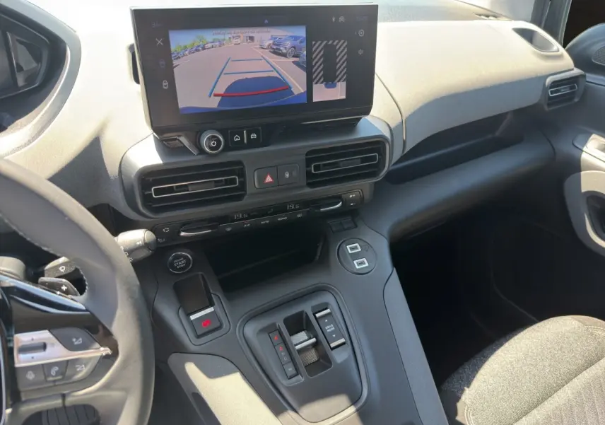 Vue intérieure du tableau de bord et console centrale du Peugeot Rifter bleu, avec écran tactile affichant la caméra de recul.