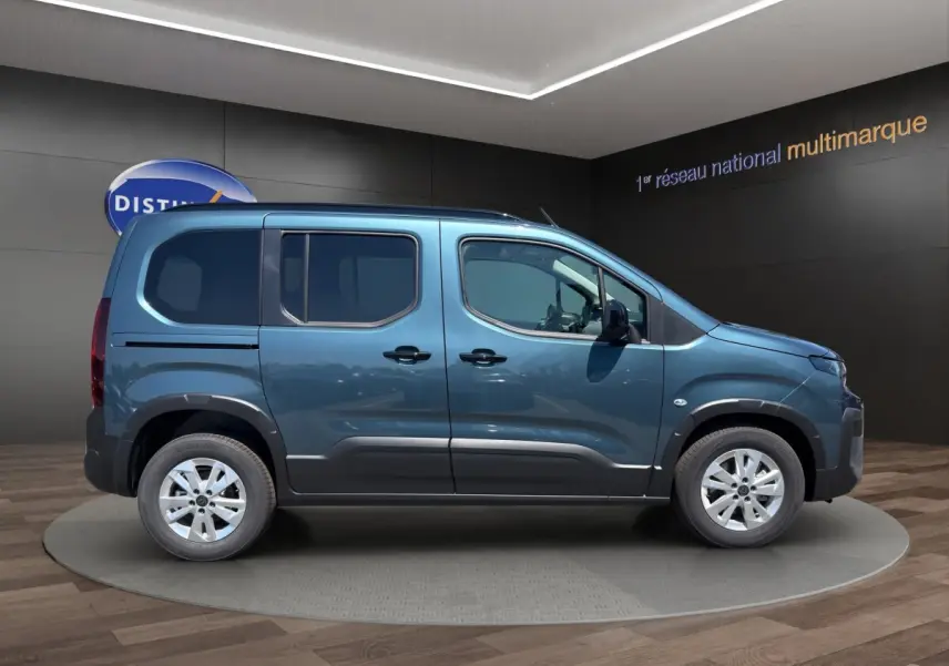 Vue latérale droite d'un Peugeot Rifter bleu 2026 avec portes coulissantes et jantes alliage.