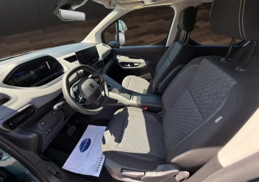 Intérieur avant du Peugeot Rifter 2026, vue côté conducteur, sièges gris et tableau de bord avec écran tactile.