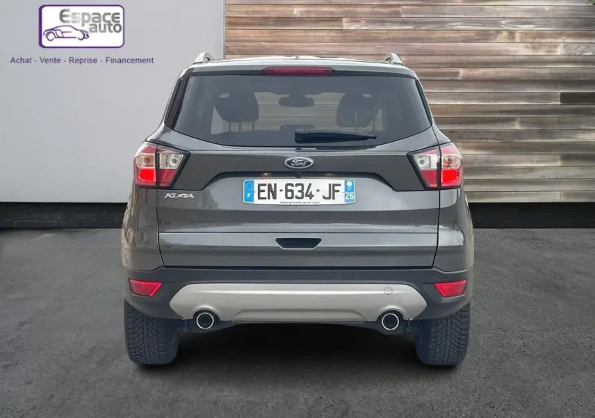 Vue arrière d'un Ford Kuga gris 2017 avec double sortie d'échappement et plaque d'immatriculation française.