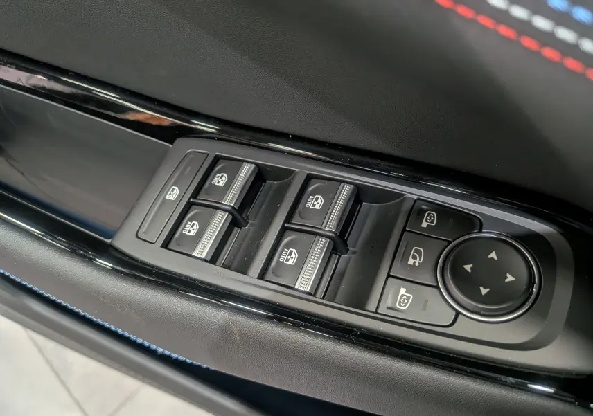 Gros plan sur les commandes des vitres électriques et rétroviseurs côté conducteur du Renault Rafale gris Schiste Satin.