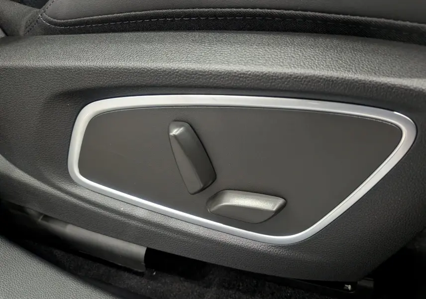 Gros plan sur les commandes de réglage électrique du siège avant en cuir noir du Renault Rafale gris Schiste Satin.