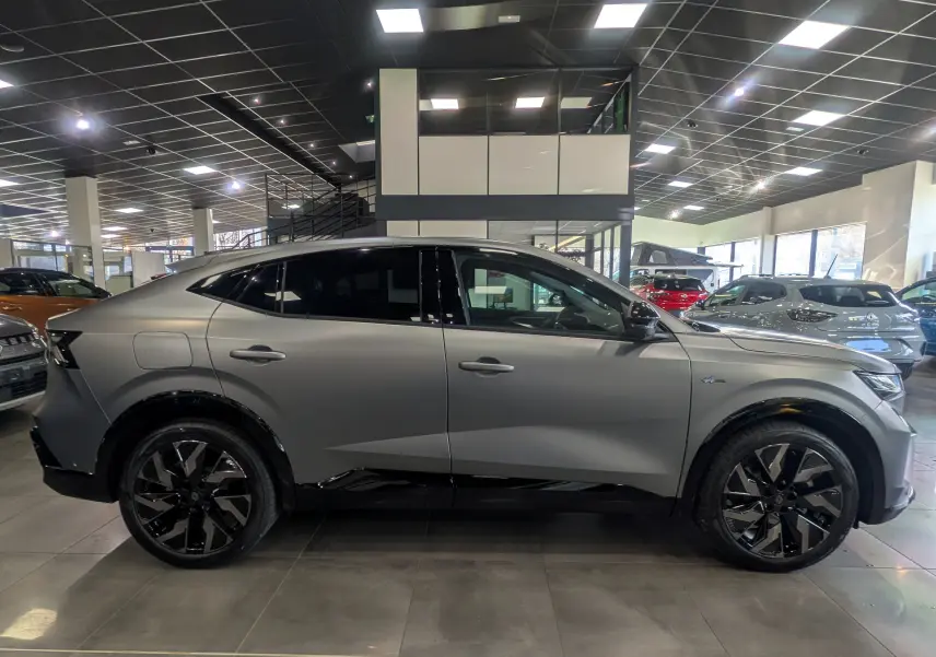 Vue latérale droite d'une Renault Rafale E-TECH gris schiste satin avec jantes noires et toit noir en concession.