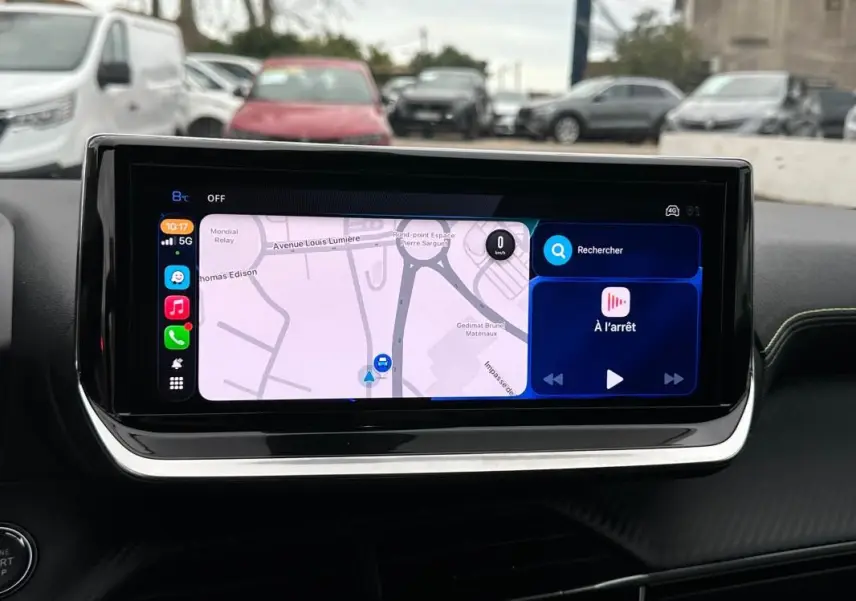 Écran tactile du tableau de bord du Peugeot 208 Hybrid 110 gris, affichant la navigation et les commandes multimédia.