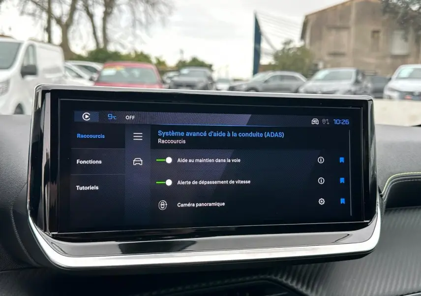 Écran tactile du tableau de bord du Peugeot 208 gris, affichant le système avancé d’aide à la conduite.