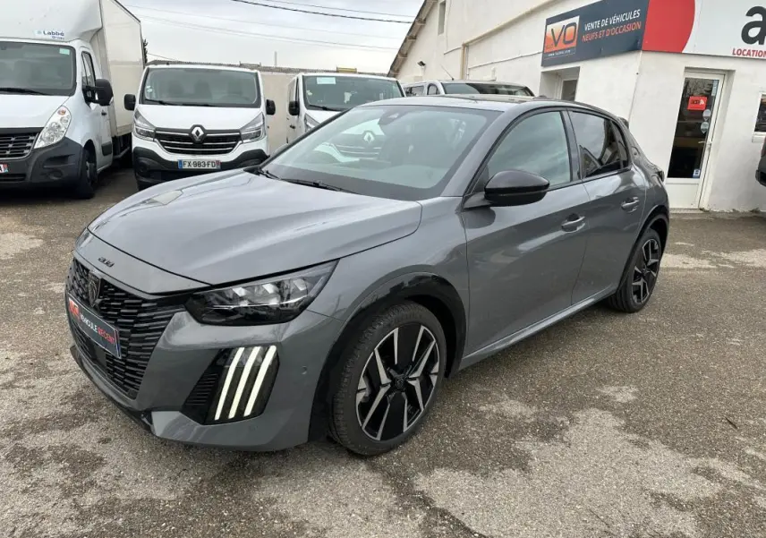 Peugeot 208 Hybrid gris vue 3/4 avant droit, avec phares LED verticaux et jantes alliage 17 pouces.
