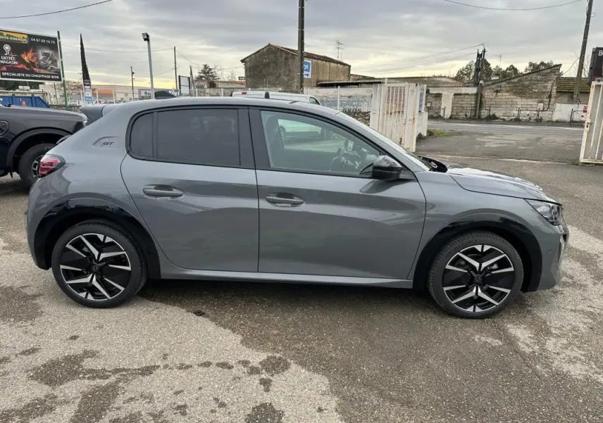 Vue de profil côté gauche d'une Peugeot 208 Hybrid 110 e-DCS6 GT gris avec jantes alliage 17 pouces.