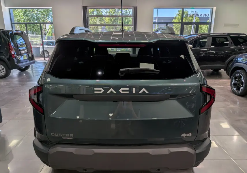 Vue arrière du Dacia Duster Hybrid-G 150 CH 4x4 en Vert Cèdre, avec logo DACIA et feux arrière en forme de C.