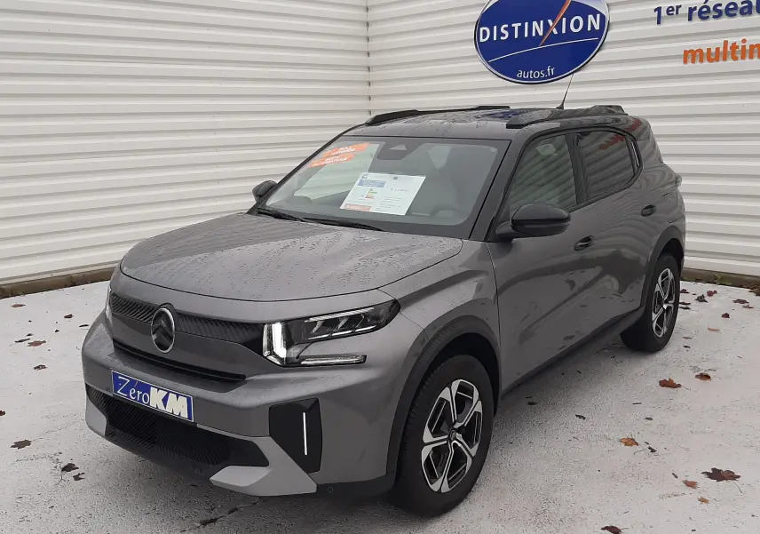 Citroën C3 Aircross 1.2 Hybrid 145 gris Mercury, vue 3/4 avant droit sous la pluie avec jantes distinctives.