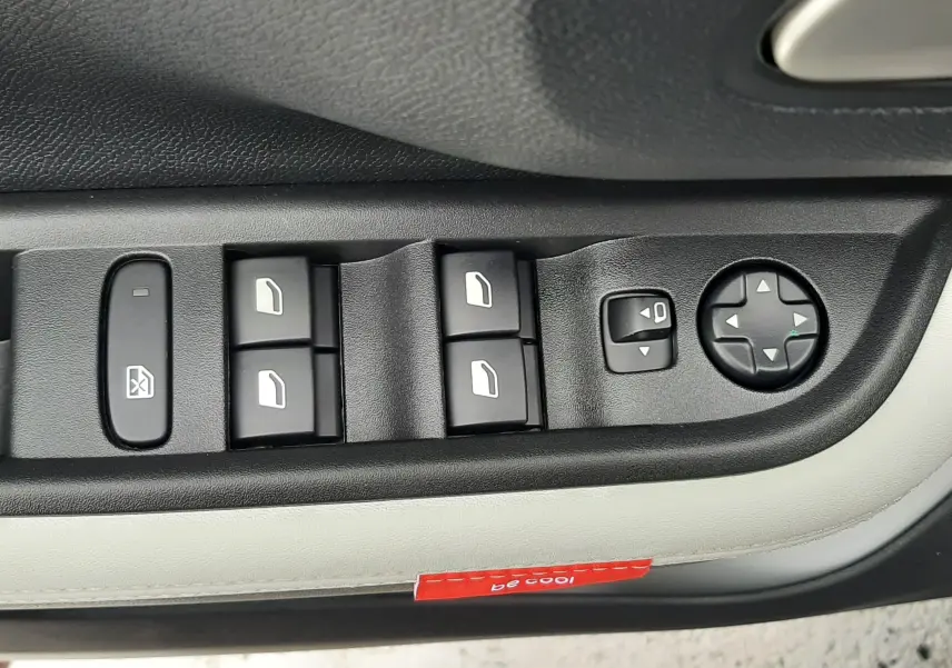 Gros plan sur les commandes de lève-vitres et réglages des rétroviseurs côté conducteur du Citroën C3 Aircross gris Mercury 2026.