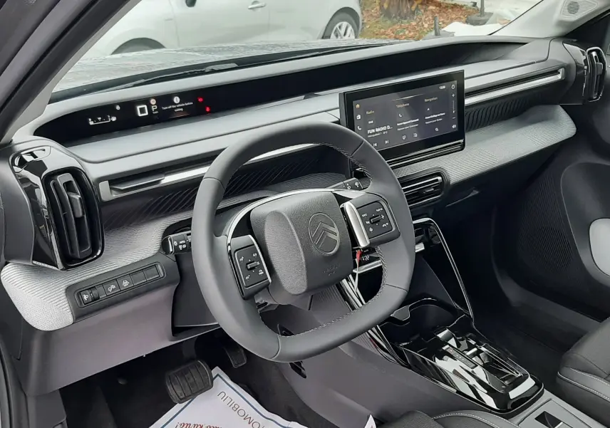 Vue intérieure côté conducteur du Citroën C3 Aircross 2026 gris Mercury, avec tableau de bord numérique et écran central tactile.