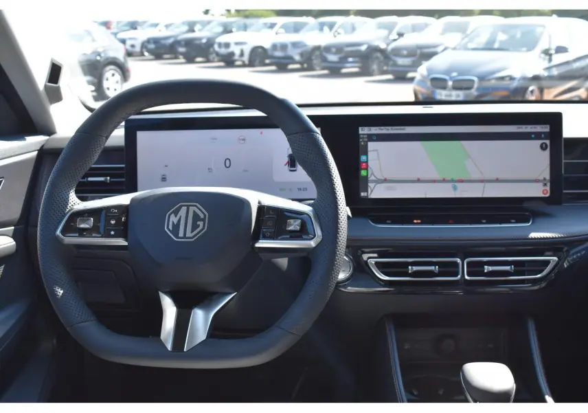 Vue intérieure centrée sur le volant noir MG et le tableau de bord numérique avec écran tactile large affichant la navigation.