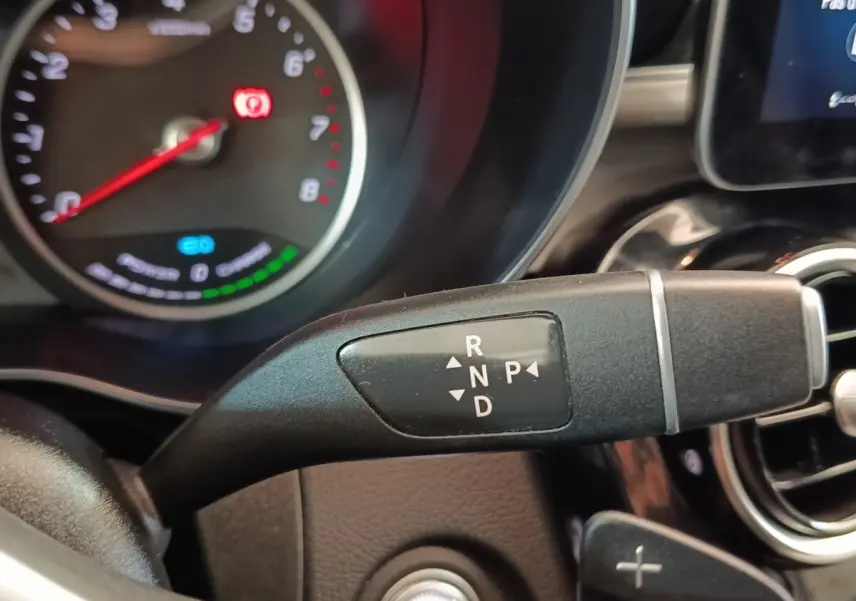 Gros plan sur la commande de boîte automatique noire dans l’habitacle d’un Mercedes GLC 300 DE bleu, tableau de bord partiellement visible.