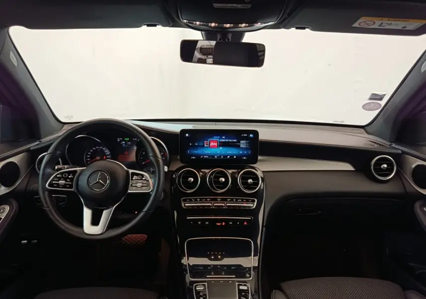 Vue intérieure avant du Mercedes GLC 300 DE Business Line 2022, tableau de bord noir avec écran tactile central et volant cuir.