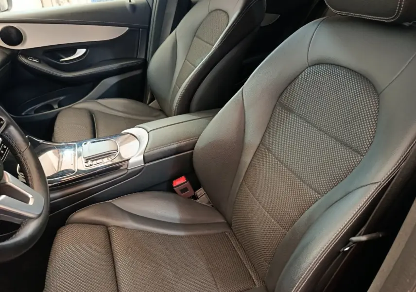 Vue intérieure côté conducteur du Mercedes GLC 300 DE Business Line 2022 avec sièges cuir noirs et console centrale brillante.